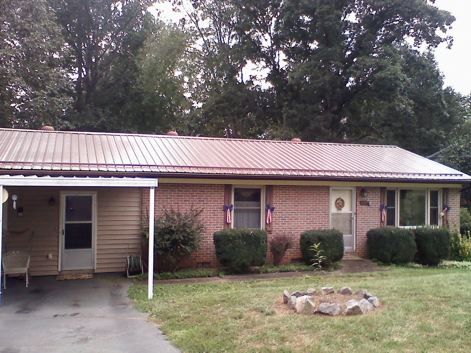 Bronze metal roof and carport on a brick ranch home — Roof Repair work by our crew in Eighty Eight